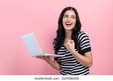 Young Woman With A Laptop Computer With Successful Pose