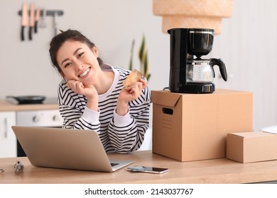 Young Woman With Laptop, Credit Card And New Coffee Maker At Home. Online Shopping