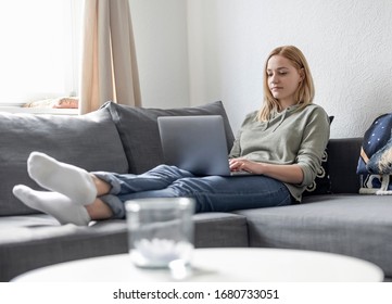 Young Woman With Laptop Lying On Couch