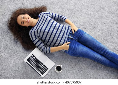 Young Woman With A Laptop Lying On The Floor