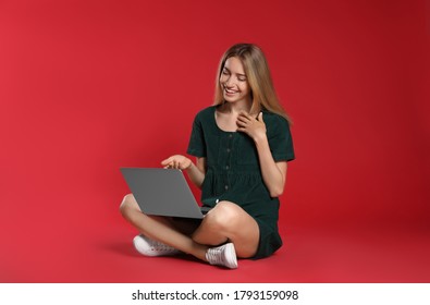 Young Woman With Laptop On Red Background