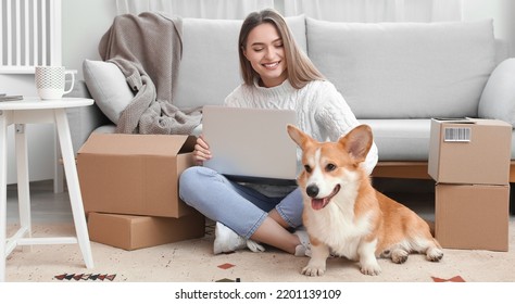 Young woman with laptop, parcels and cute dog at home. Online shopping concept