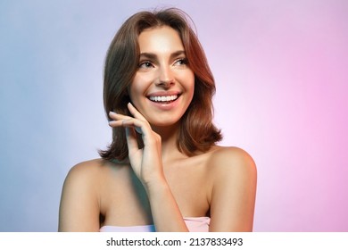 Young Woman Laughing Looking Aside Studio Portrait On Blue Copy Space. Beautiful Girl With Naked Shoulder, Shiny Glowing Perfect Skin Isolated Headshot