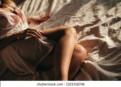 Young Woman Is Laying At The Bed. She Is Wearing Pyjamas.