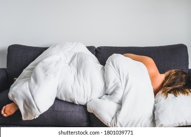 Young Woman Laying Down Sleeping On Couch With Large Duvet 