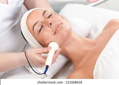 Young Woman Laying Eyes Closed, Receiving Facial Beauty Treatment In Beauty Saloon.