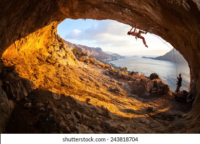 Young Woman Lead Climbing In Cave With Beautiful View In Background 