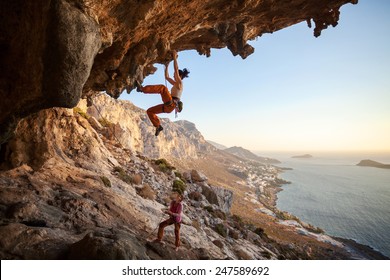 Young Woman Lead Climbing In Cave With Beautiful View In Background 