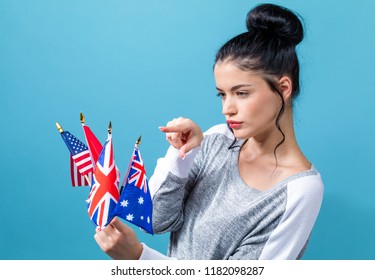Young woman with learn English theme with the flags of English speaking countries on a blue background