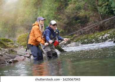 Young Woman Learning To Fly Fishing With A Guide