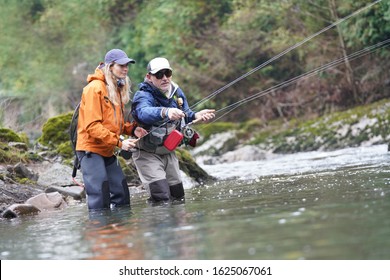 Young Woman Learning To Fly Fishing With A Guide