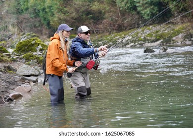 Young Woman Learning To Fly Fishing With A Guide