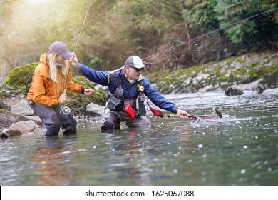 Young Woman Learning To Fly Fishing With A Guide