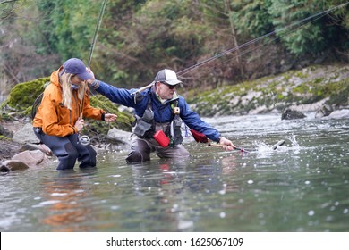 Young Woman Learning To Fly Fishing With A Guide