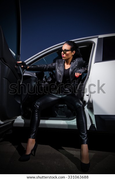 Young woman in leather\
clothes with car