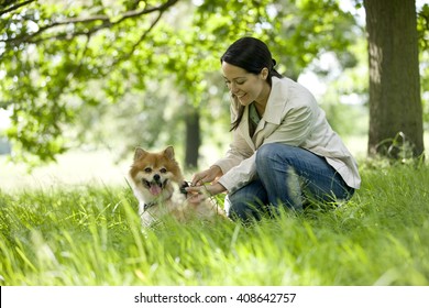 A Young Woman Letting Her Dog Off Its Lead