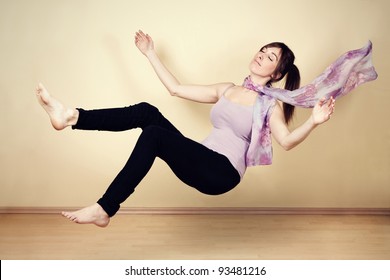 Young woman levitating in empty room