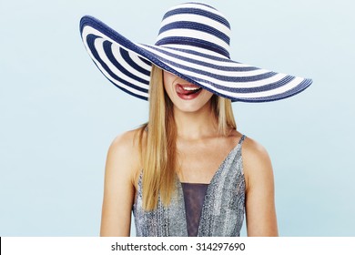 Young Woman Licking Lips In Striped Hat