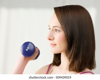 Young Woman Lifting Dumb Bells, Close Up