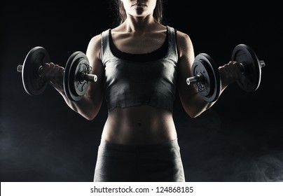 Young Woman Lifting The Dumbbells