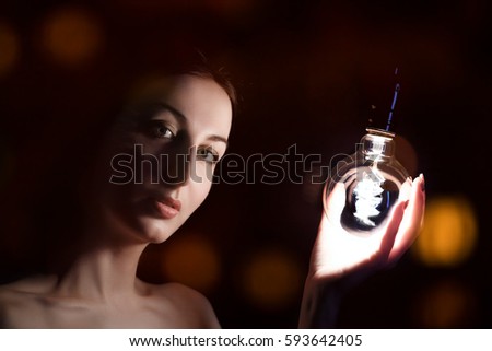 young woman with light bulb in hand on black background