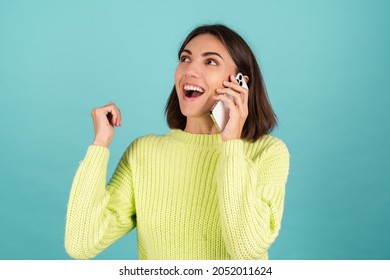 Young Woman In Light Green Sweater With Mobile Phone Having Conversation Listen Audio Message Happy Excited Winner Yay