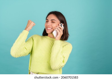 Young Woman In Light Green Sweater With Mobile Phone Having Conversation Listen Audio Message Happy Excited Winner Yay