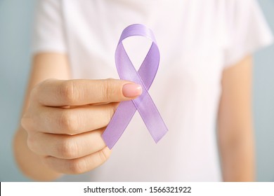 Young woman with lilac ribbon on grey background, closeup. Cancer awareness concept - Shutterstock ID 1566321922
