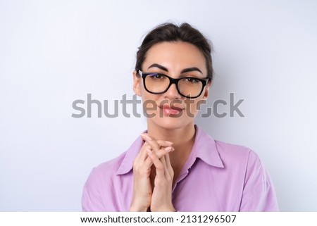 Young woman in a lilac shirt on a white background in glasses for vision cheerful positive in a good mood