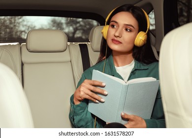 Young Woman Listening To Audiobook In Car