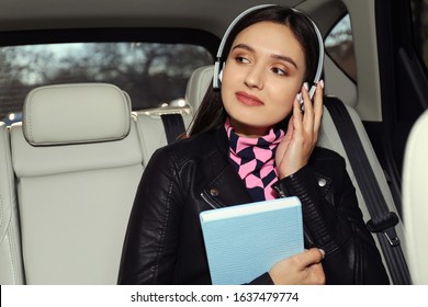 Young Woman Listening To Audiobook In Car