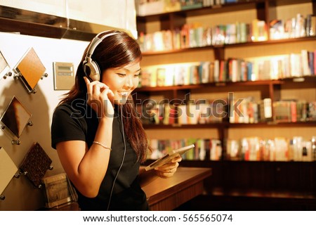 Young woman listening to music, smiling, holding CD