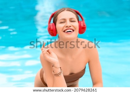 Young woman listening to music in swimming pool