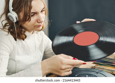 Young Woman Listening To Music From Vinyl Record Player. Playing Music On Turntable Player. Female Enjoying Music From Old Record Collection At Home. Stack Of Analog Vinyl Records. Retro And Vintage