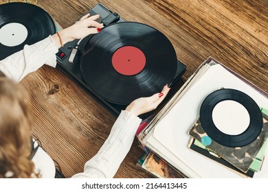 Young Woman Listening To Music From Vinyl Record Player. Playing Music On Turntable Player. Female Enjoying Music From Old Record Collection At Home. Stack Of Analog Vinyl Records. Retro And Vintage