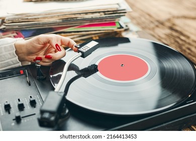 Young Woman Listening To Music From Vinyl Record Player. Playing Music On Turntable Player. Female Enjoying Music From Old Record Collection At Home. Stack Of Analog Vinyl Records. Retro And Vintage