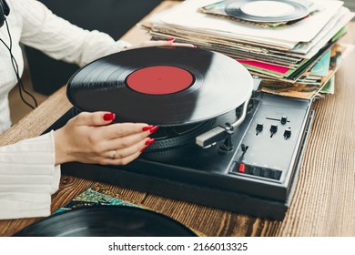 Young Woman Listening To Music From Vinyl Record Player. Playing Music On Turntable Player. Female Enjoying Music From Old Record Collection At Home. Stack Of Analog Vinyl Records. Music Passion