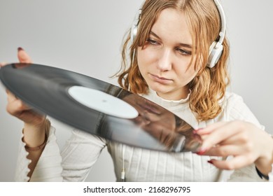 Young Woman Listening To Music From Vinyl Record Player. Playing Music On Turntable Player. Female Enjoying Music From Old Record Collection At Home. Stack Of Analog Vinyl Records. Retro And Vintage