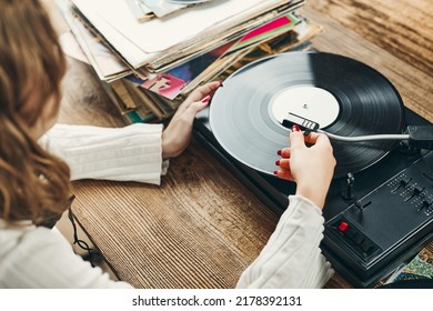 Young Woman Listening To Music From Vinyl Record Player. Playing Music On Turntable Player. Female Enjoying Music From Old Record Collection At Home. Stack Of Analog Vinyl Records. Retro And Vintage