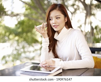 young woman listening to voice message using mobile phone.