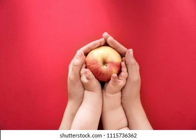 Junge Frau und kleines Kind, die Apfel auf Farbhintergrund halten, Draufsicht. Gesunde Ernährung