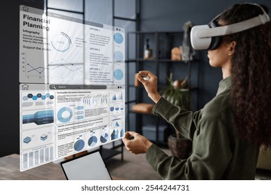 Young woman with long curly hair standing in living room using VR headset for financial education - Powered by Shutterstock