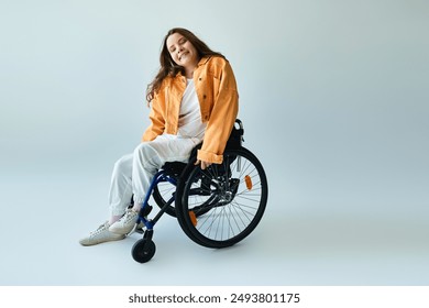 A young woman with long, dark hair sits in a wheelchair, dressed in a stylish, casual outfit, smiling against a grey backdrop. - Powered by Shutterstock