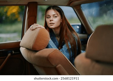 Young woman with long hair in a cozy car interior, wearing a denim jacket, looking thoughtfully out of the window, capturing a serene and contemplative moment. - Powered by Shutterstock