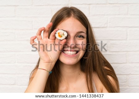 Young woman with long hair eating sushi