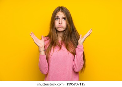 Young woman with long hair over isolated yellow wall frustrated by a bad situation