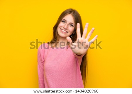 Young woman with long hair over isolated yellow wall counting five with fingers