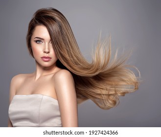 Young Woman With Long Straight Hair. Sexy And Gorgeous Blonde Woman. Portrait Of An Attractive Female Posing At Studio. Closeup Face Of A Beautiful Girl With Makeup Smoky Eyes.