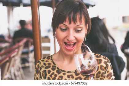 Young Woman Looking At Almost Empty Glass Of Wine In Surprise