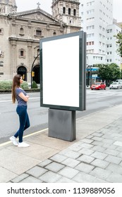 Young Woman Looking At A Billboard In The City